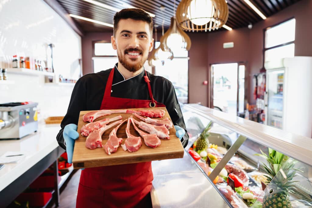 About Me 2 young butcher holding raw lamb ribs in a butcher s 2023 11 27 05 24 31 utc 1